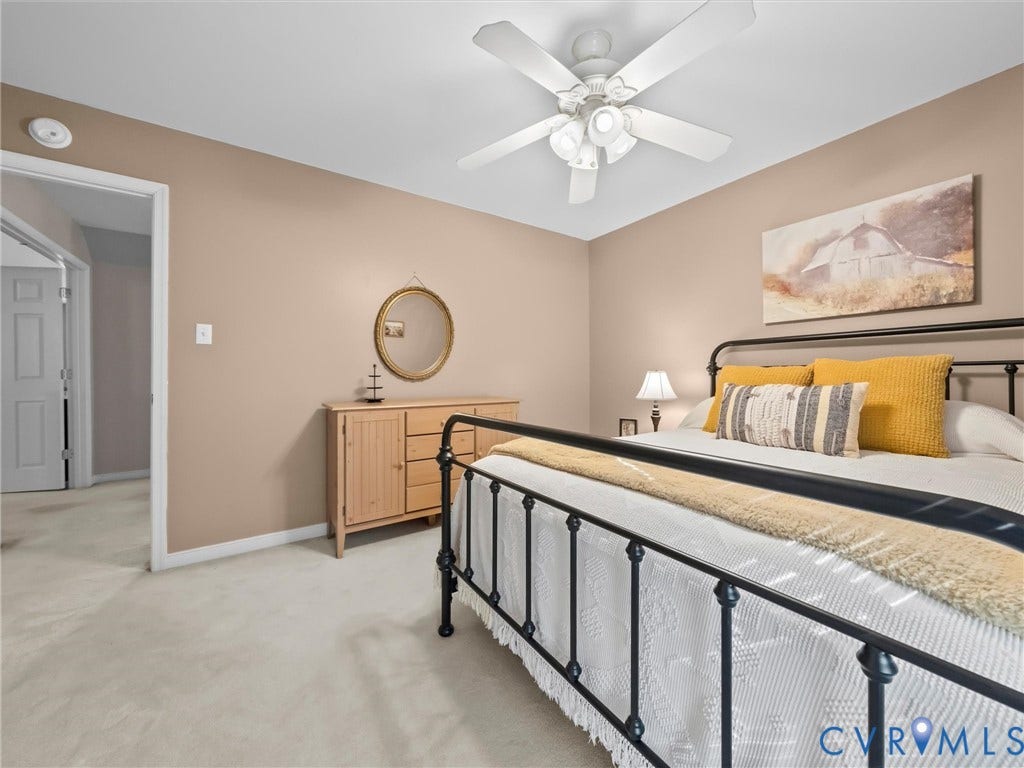 Neutral wall paint, ceiling fan light fixture, and soft carpet flooring
