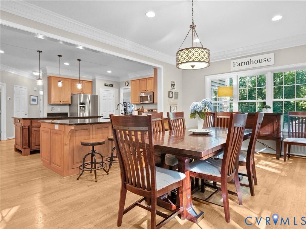 Bright dining area with wood-finish flooring and a decorative chandelier