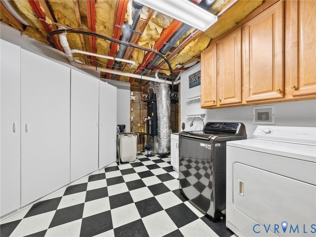 Black and white checkerboard flooring, extensive white built-in cabinetry, additional wood-finish upper cabinetry, and fluorescent overhead lighting