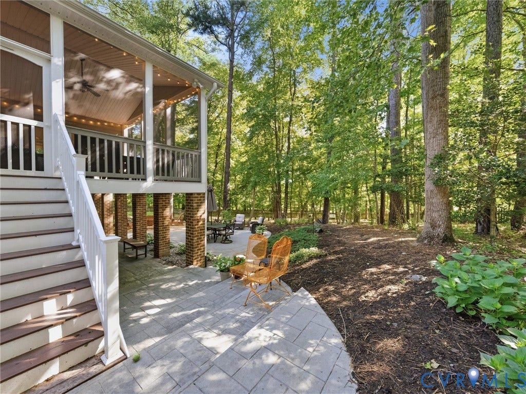 Screened-in porch with a vaulted ceiling, wood-finish flooring, and a ceiling fan