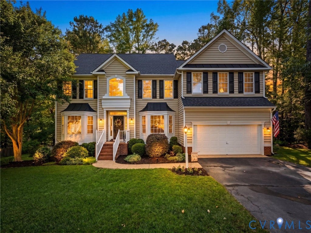 Two-story residence featuring light-toned siding and dark shutters