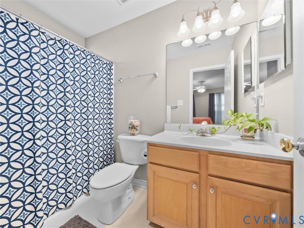 Single vanity with an integrated sink, a large wall-mounted mirror, and a built-in light fixture