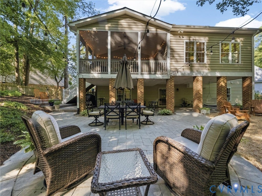 Screened porch with white railings, a patio with brick columns, and a terraced yard