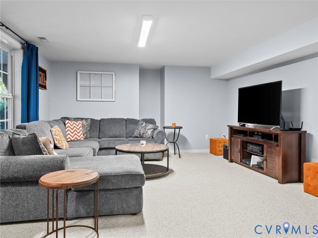 Recessed ceiling with integrated lighting, window with white trim, light gray walls, and light-colored carpeting