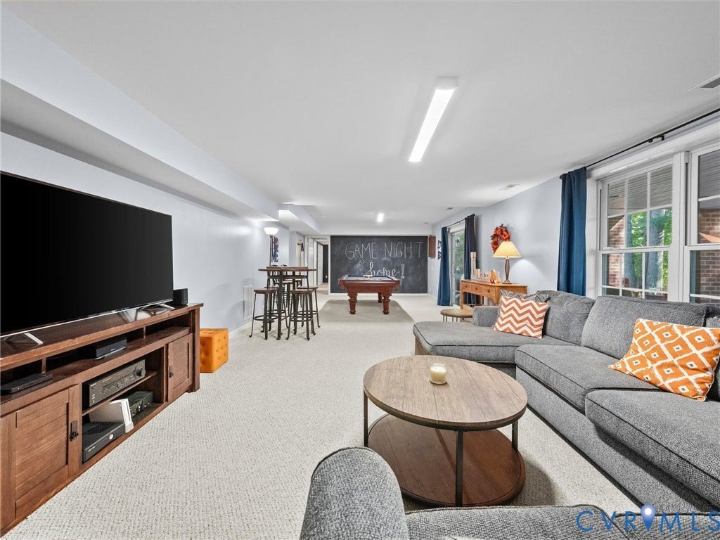 Expansive finished lower level featuring recessed lighting, light-colored carpeting, and egress windows