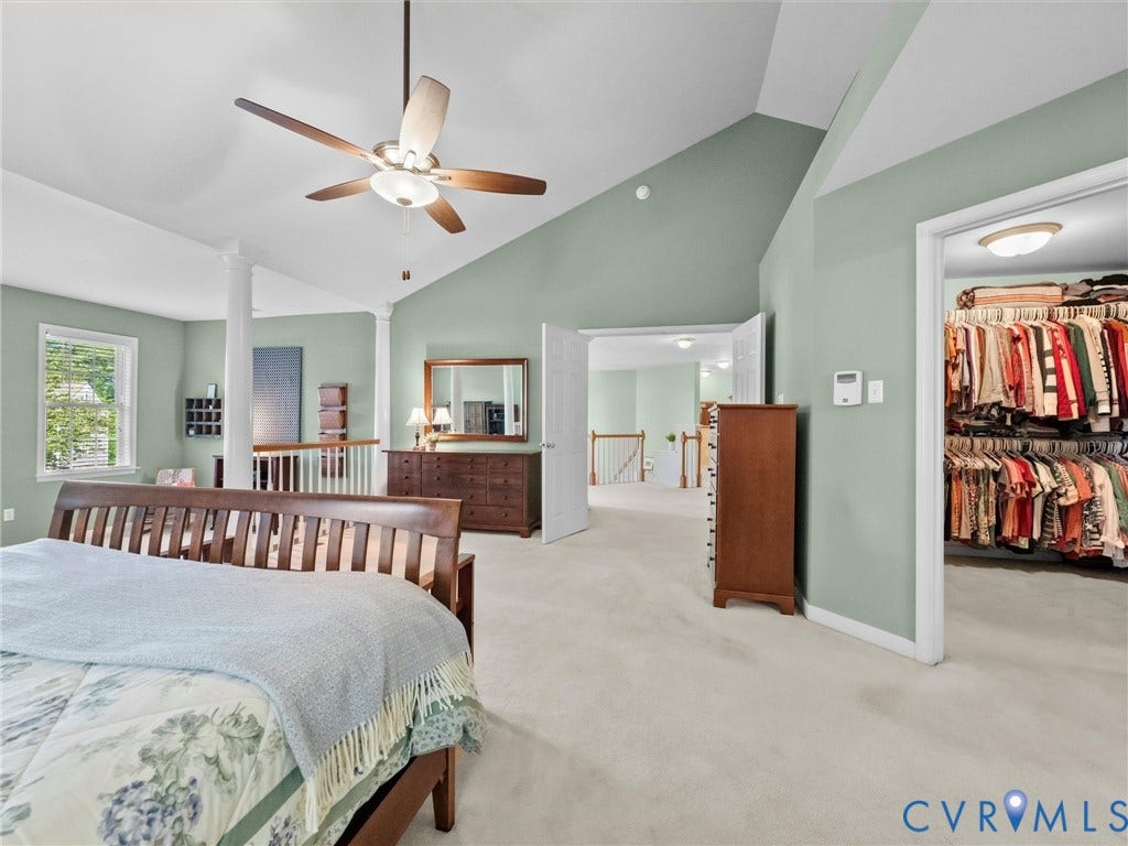 Vaulted ceiling, ceiling fan, carpeted flooring, open doorway to closet, and white trim