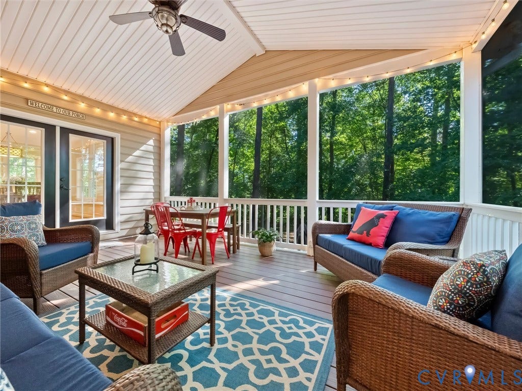 Screened-in porch featuring a vaulted ceiling and a ceiling fan