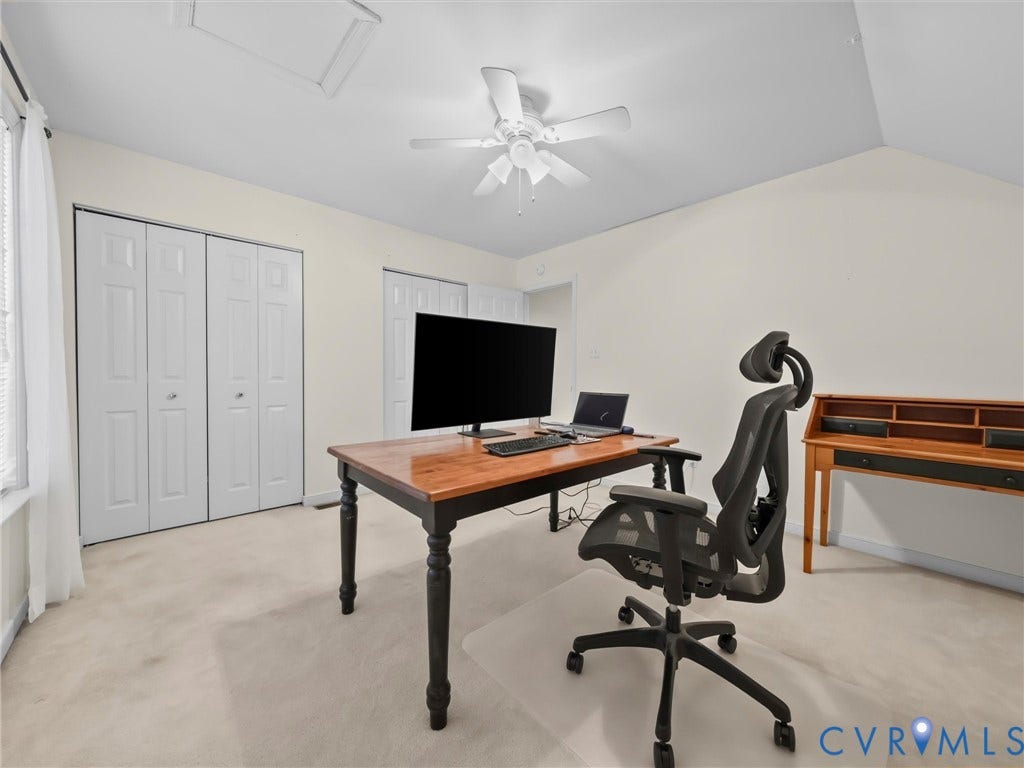 Vaulted ceiling, ceiling fan, wall-to-wall carpeting, multiple bi-fold closet doors, and sloped ceiling