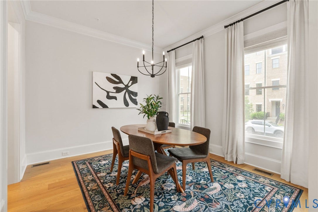 Tall windows and hardwood floors create a bright, elegant dining space.
