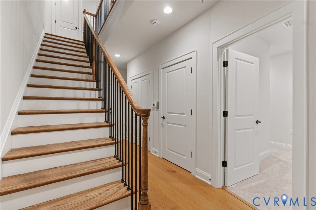 Stairs leading down to the lower level where youll find another spacious bedroom with en suite, elevator access and garage access.