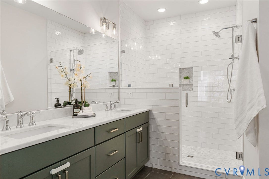 Bright finishes and recessed lighting create an inviting primary bath.