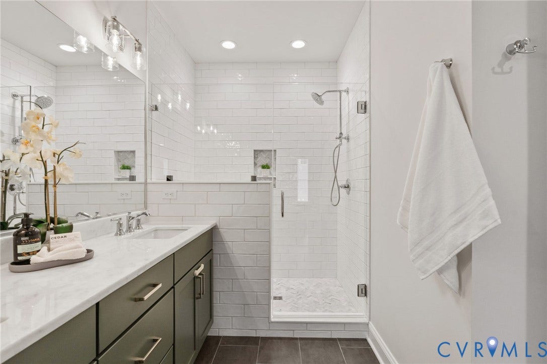 Spacious primary bath with a wide vanity and generous mirror space.