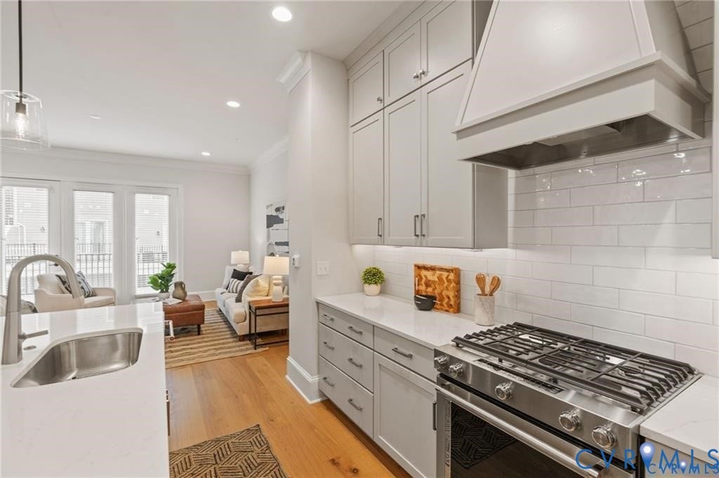 Gas cooking and a substantial range hood complement the kitchens classic white finishes.