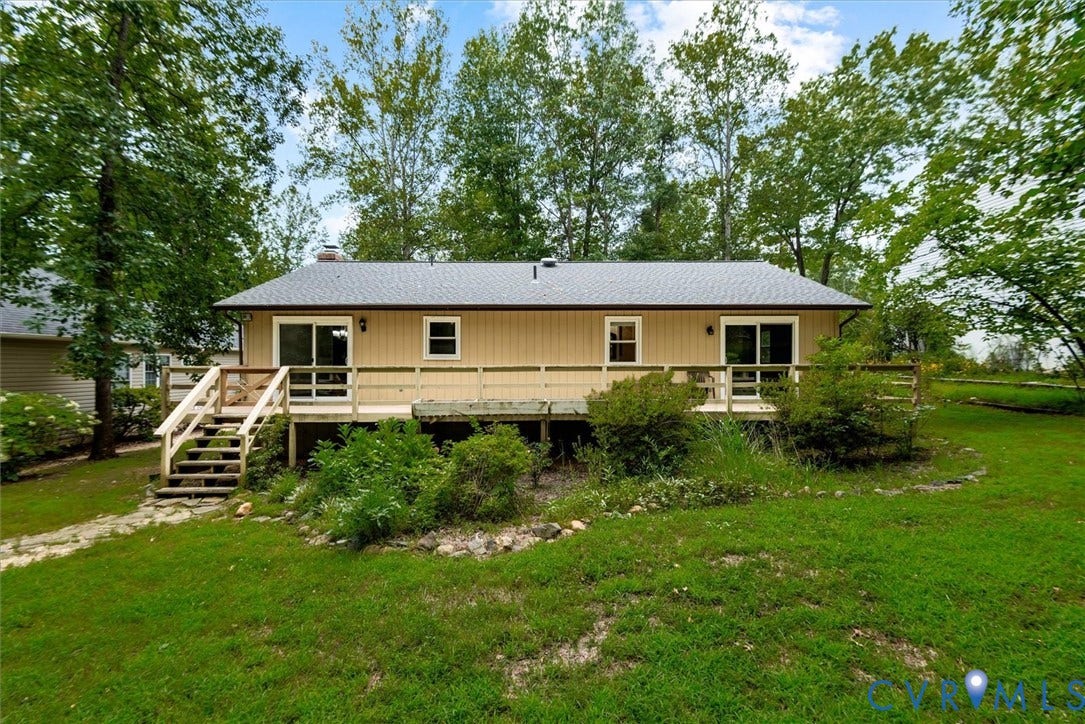 Single-story residence featuring a neutral-toned exterior, a dark shingle roof, and a rear elevated wood deck