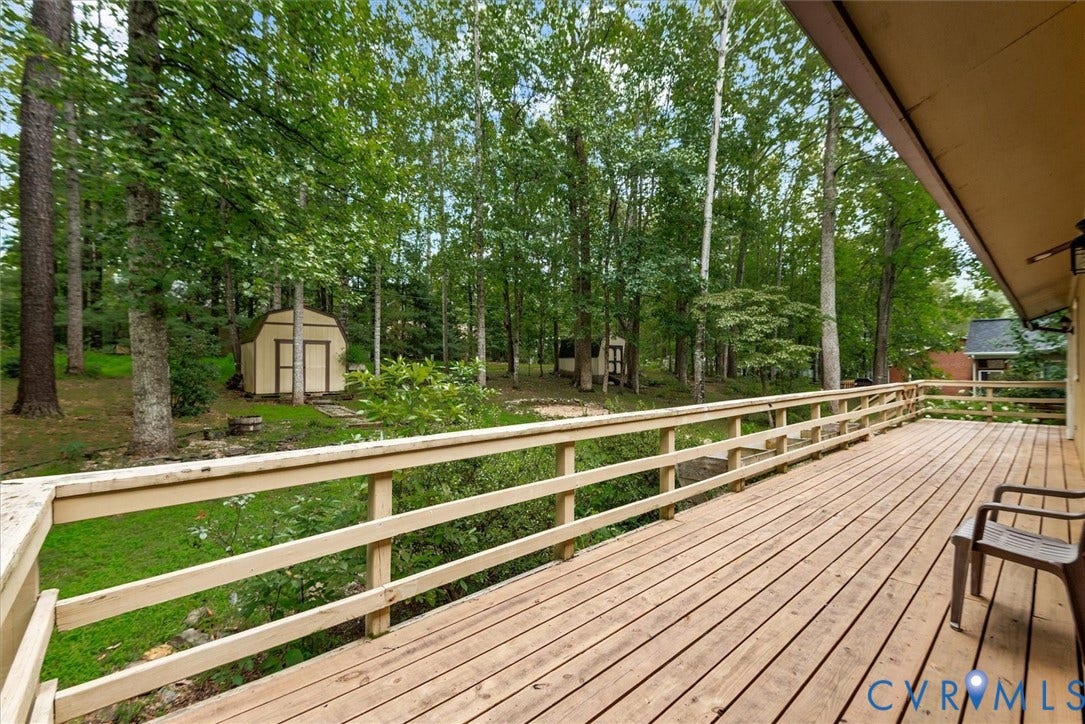Spacious wood-finish deck with a wood railing, offering expansive outdoor living