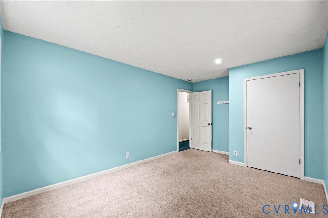 Recessed ceiling lighting, light blue wall paint, and neutral tone carpeting