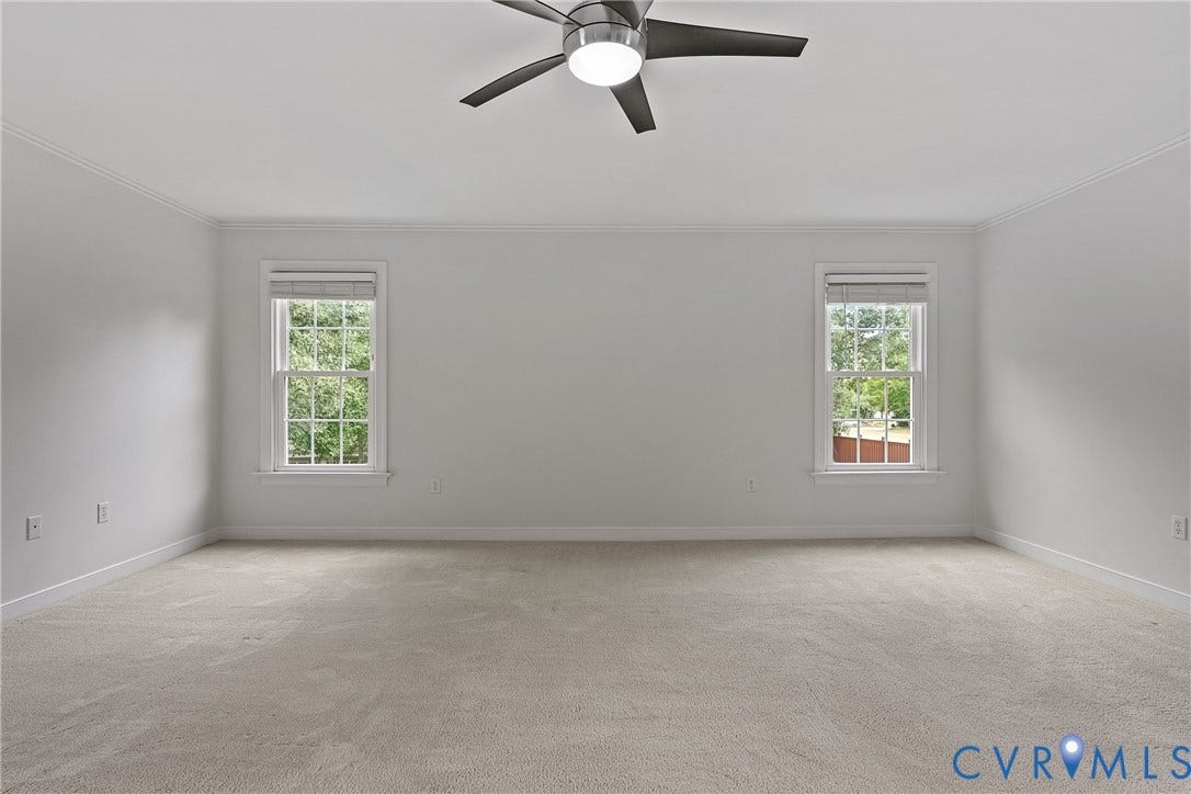 11100 Glen Hollow Court, Henrico, VA 23233 Spacious room featuring neutral carpeting, two windows with blinds, and a ceiling fan with integrated lighting