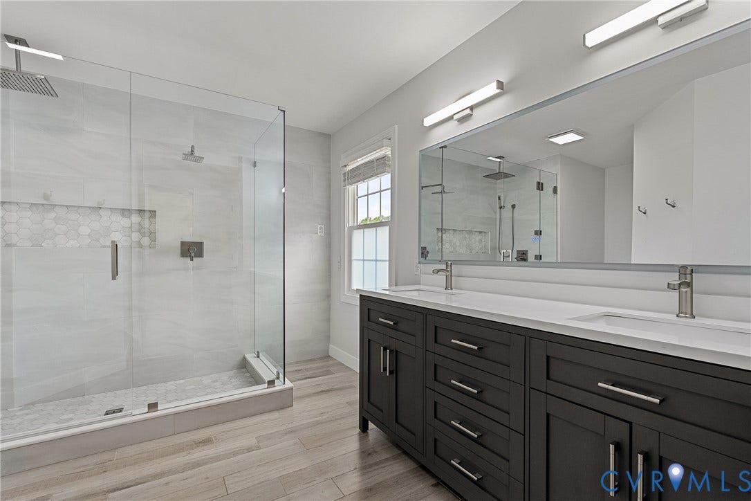 11100 Glen Hollow Court, Henrico, VA 23233 Glass-enclosed shower with a rainfall showerhead, dual vanity with undermount sinks, and wood-finish flooring