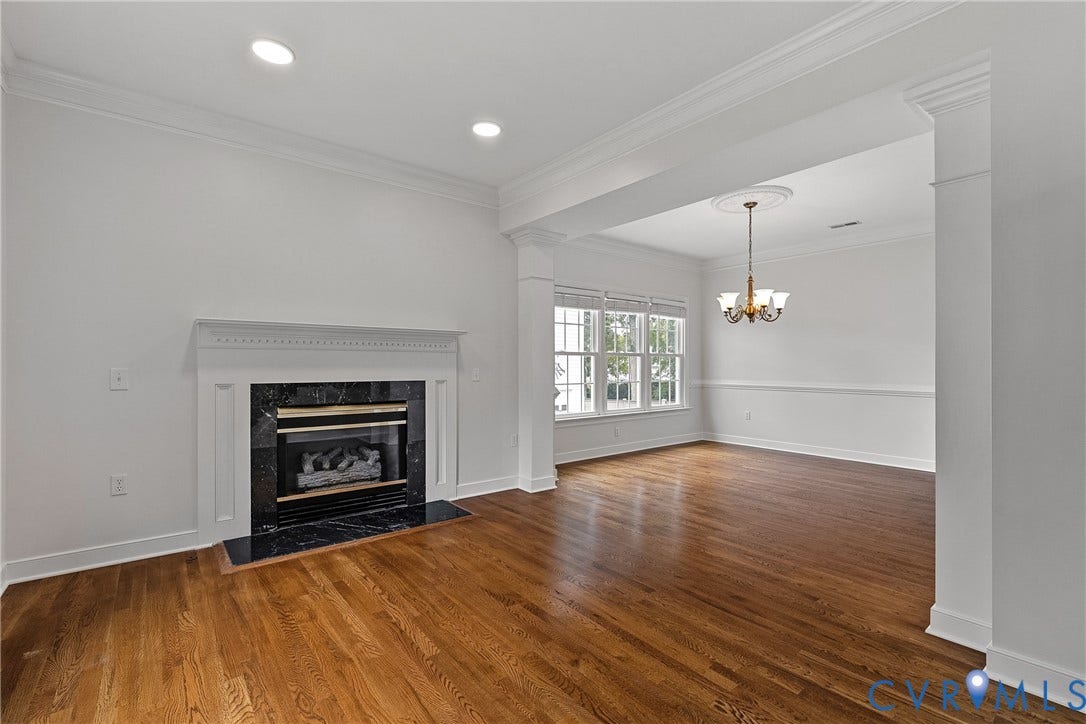 11100 Glen Hollow Court, Henrico, VA 23233 Hardwood flooring, recessed lighting, fireplace with stone surround, crown molding, and a decorative chandelier