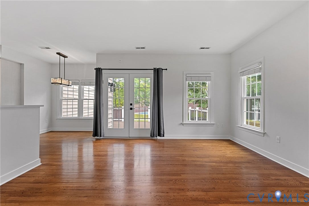 11100 Glen Hollow Court, Henrico, VA 23233 Hardwood flooring, white walls, multiple windows, double glass panel doors, and a rectangular pendant light fixture