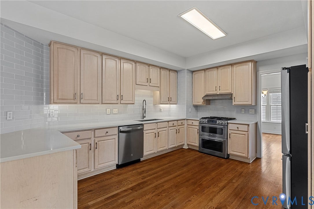 11100 Glen Hollow Court, Henrico, VA 23233 Kitchen featuring wood-finish cabinetry, stainless steel appliances, solid surface countertops, and subway tile backsplash