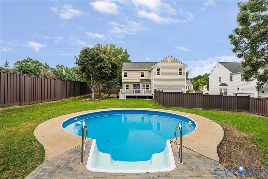 11100 Glen Hollow Court, Henrico, VA 23233 Private backyard featuring an in-ground swimming pool with stone paver surround, expansive lawn, and a full privacy fence