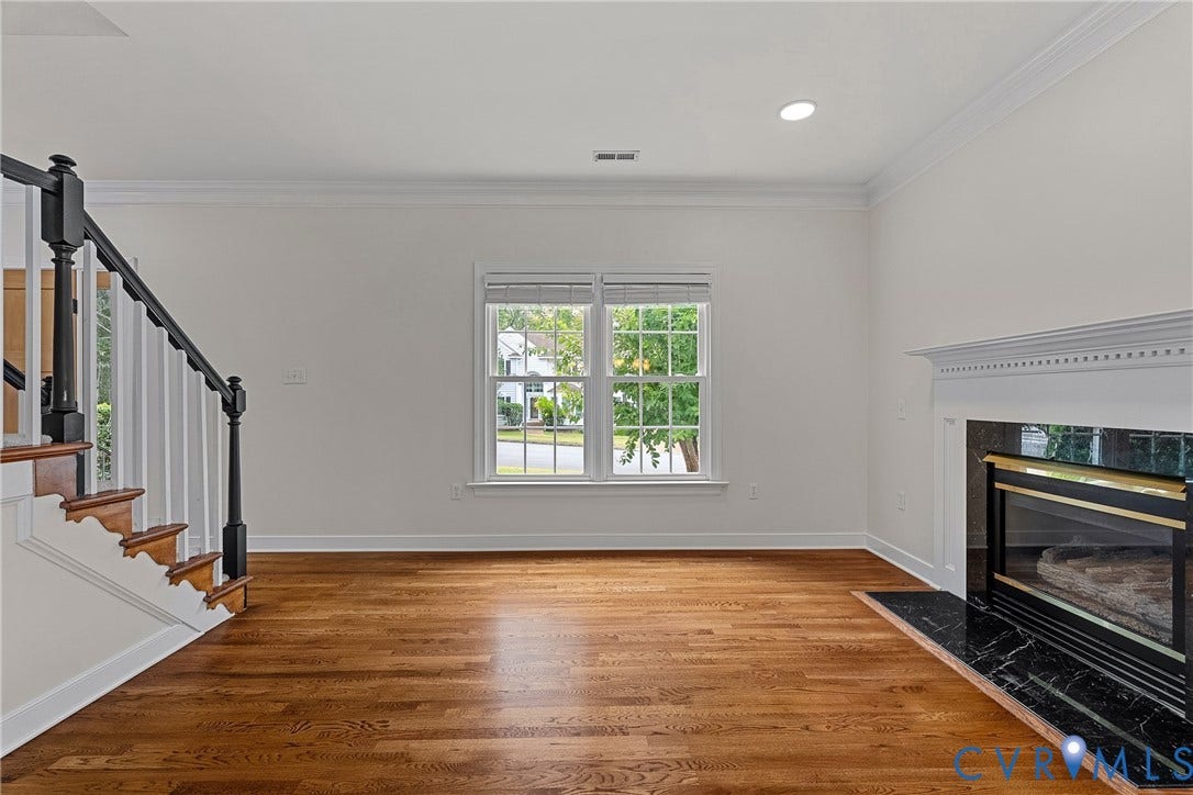 11100 Glen Hollow Court, Henrico, VA 23233 Hardwood flooring, white crown molding, recessed lighting, white wood window trim, and a fireplace with a black stone surround