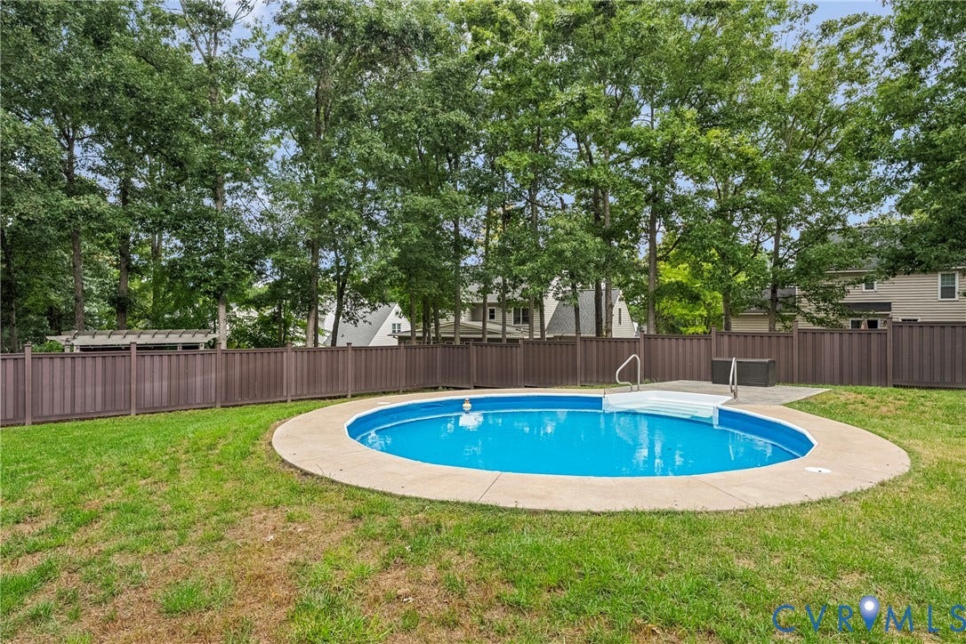 11100 Glen Hollow Court, Henrico, VA 23233 Fenced backyard featuring an oval-shaped swimming pool with concrete surround and a grass lawn
