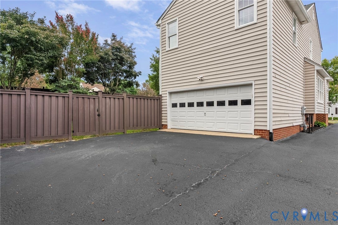 11100 Glen Hollow Court, Henrico, VA 23233 Attached garage with a white panel door, light-toned siding, and a brick foundation