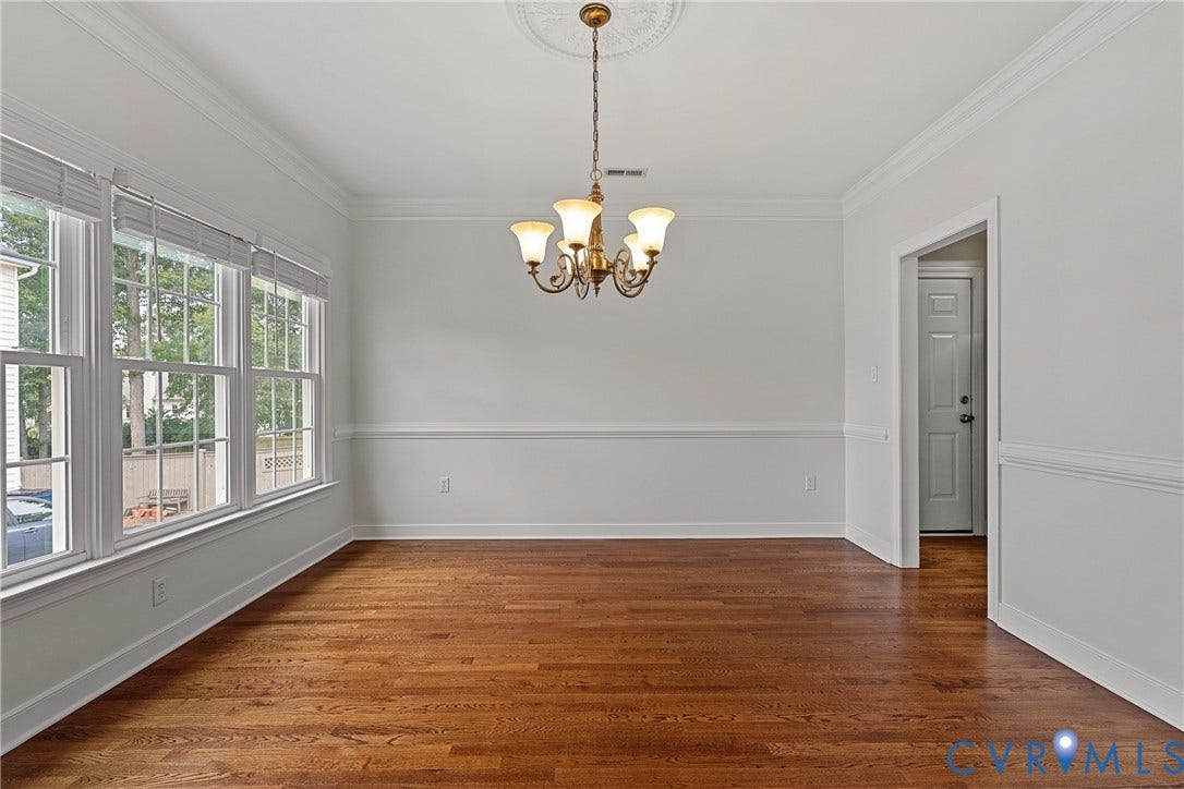 11100 Glen Hollow Court, Henrico, VA 23233 Hardwood flooring, crown molding, chair rail detailing, a multi-pane window bank, and a decorative ceiling medallion with a chandelier