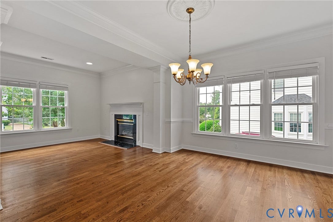 11100 Glen Hollow Court, Henrico, VA 23233 Hardwood flooring, white crown molding, recessed lighting, fireplace with dark stone surround, and a decorative ceiling medallion with a chandelier