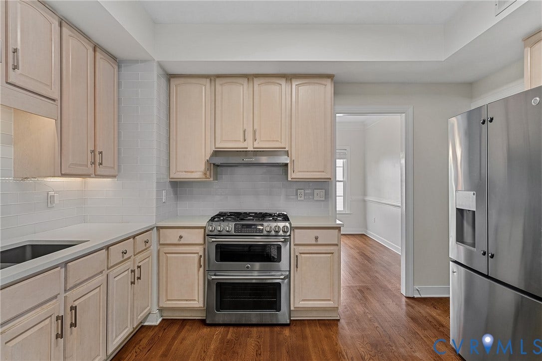 11100 Glen Hollow Court, Henrico, VA 23233 Kitchen featuring light-toned cabinetry, stainless steel appliances, a subway tile backsplash, and wood-finish flooring