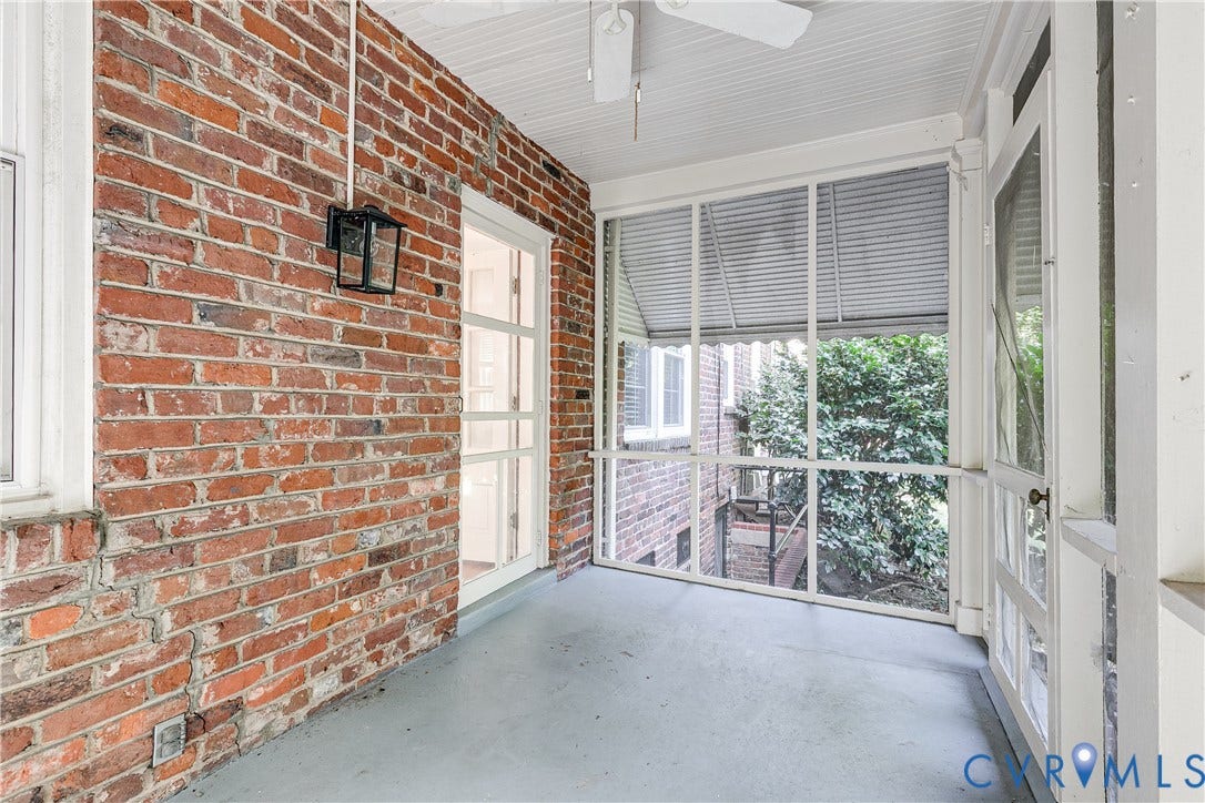 4010 Patterson Avenue, #1stfl, Richmond, VA 23221 Screened porch featuring a brick wall, painted concrete flooring, a white ceiling fan, and white frame windows