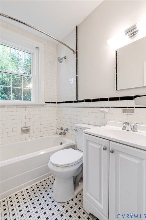 4010 Patterson Avenue, #1stfl, Richmond, VA 23221 White subway tile walls, black and white mosaic floor, white vanity with polished chrome hardware, chrome single-handle faucet, and a window with a white frame