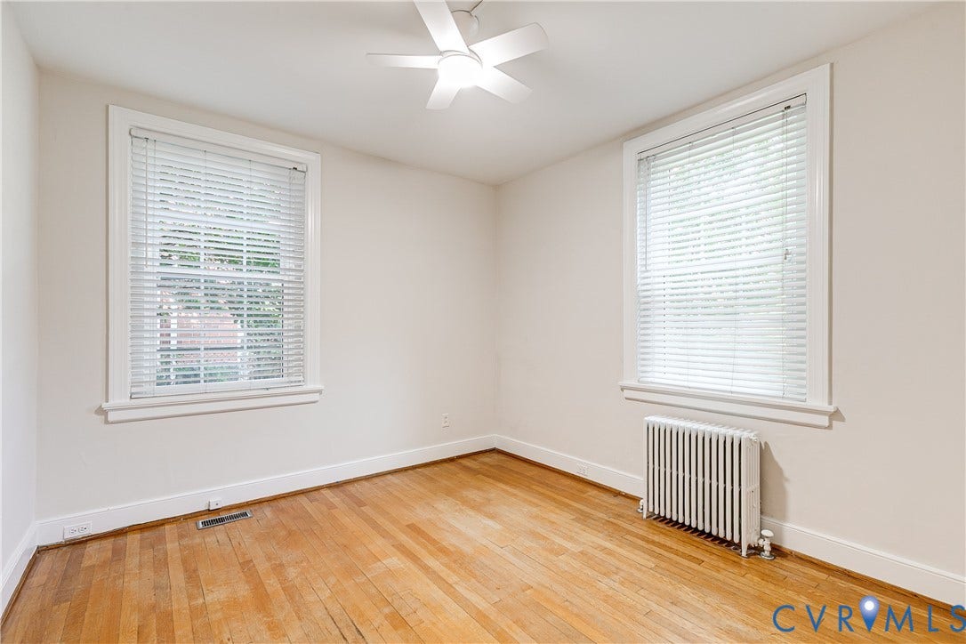 4010 Patterson Avenue, #1stfl, Richmond, VA 23221 Hardwood flooring, two windows with blinds, ceiling fan, and a radiator