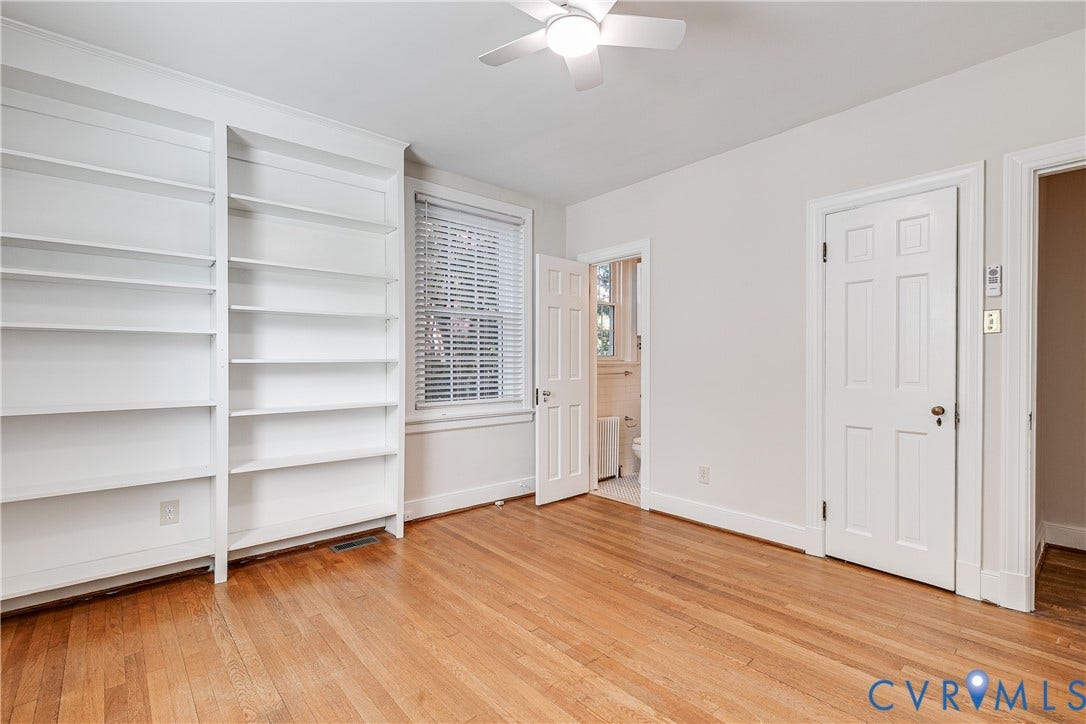 4010 Patterson Avenue, #1stfl, Richmond, VA 23221 Wood-finish flooring, white built-in shelving, a ceiling fan, and a paneled door