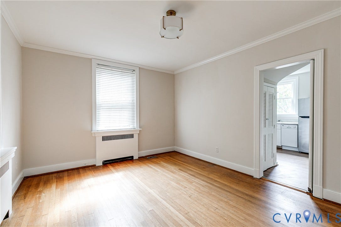 4010 Patterson Avenue, #1stfl, Richmond, VA 23221 Hardwood flooring, crown molding, window with blinds, baseboard heating unit, and an arched doorway