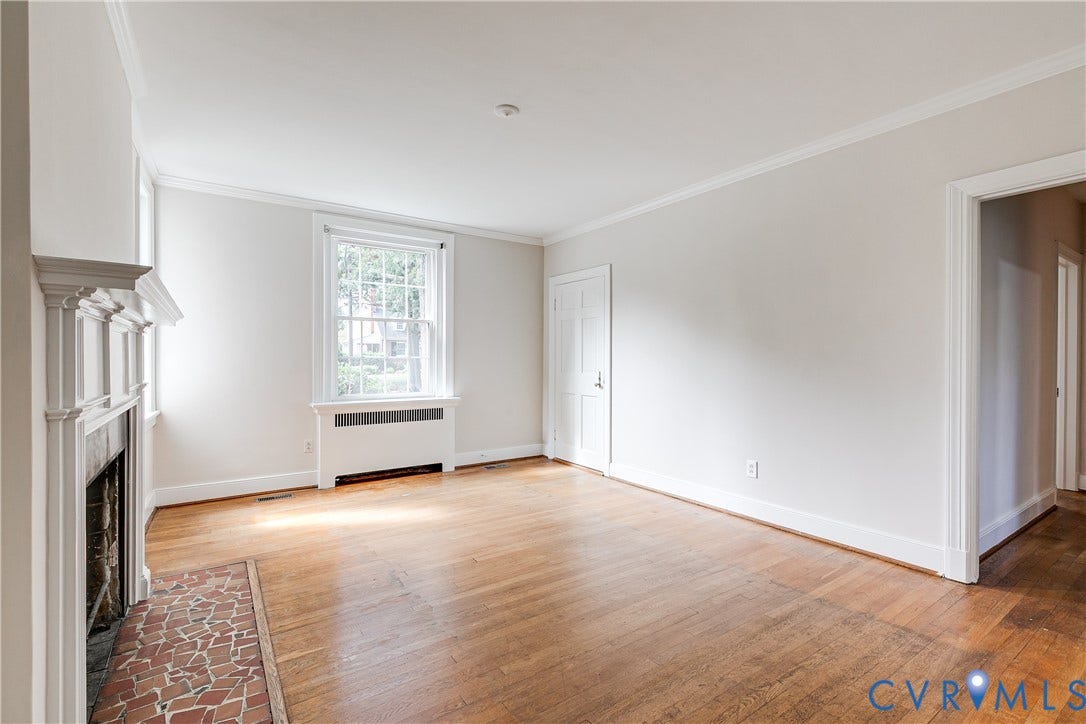 4010 Patterson Avenue, #1stfl, Richmond, VA 23221 Hardwood flooring, white crown molding, a decorative fireplace with a tile hearth, and a double-hung window