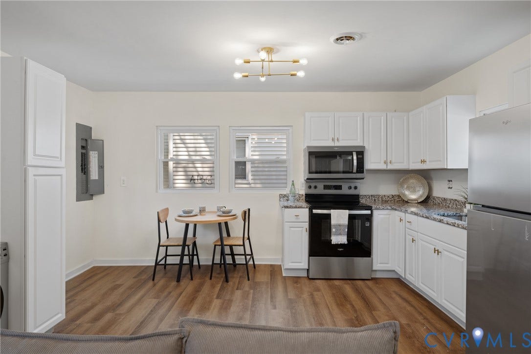 2911 Poplar Street, Hopewell, VA 23860 White cabinetry with gold-tone hardware, stainless steel appliances, granite countertops, wood-finish flooring, and a modern ceiling fixture