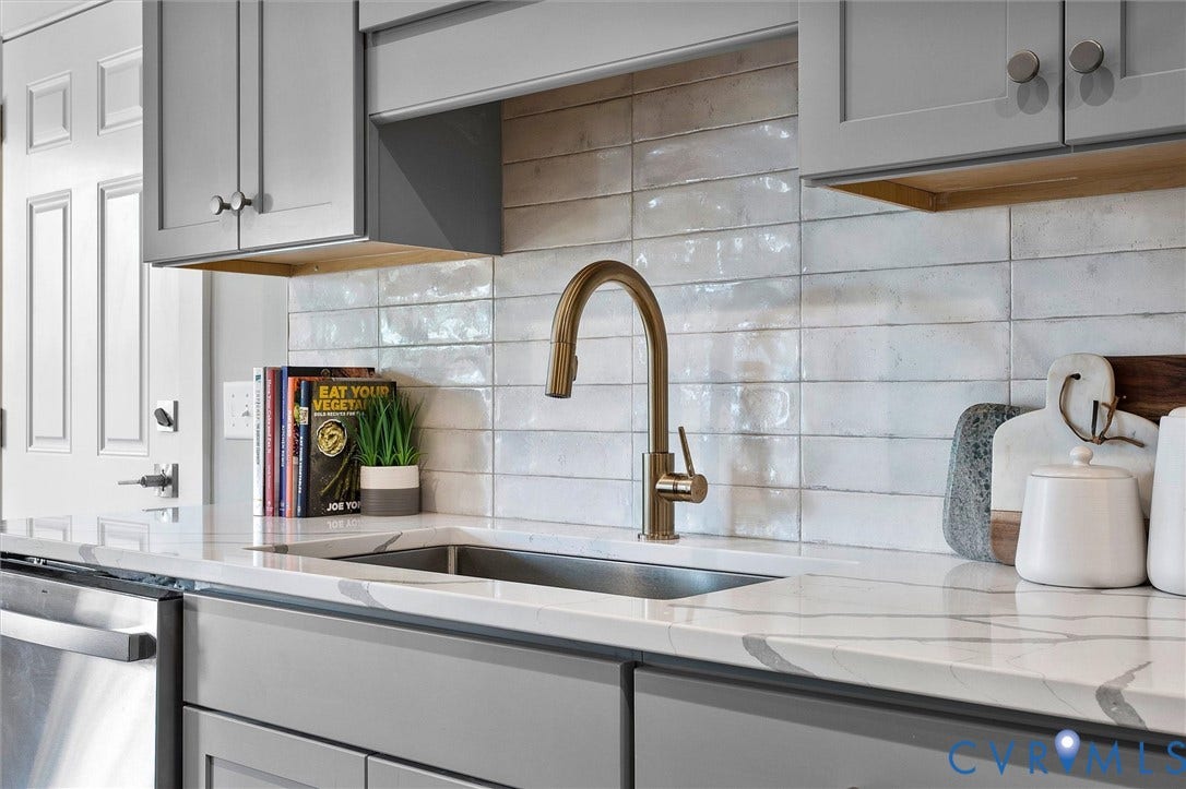 2902 Idlewood, #5, Richmond, VA 23221 Integrated stainless steel sink with a gold-tone faucet, complemented by a white subway tile backsplash, light-toned countertops, and gray cabinetry