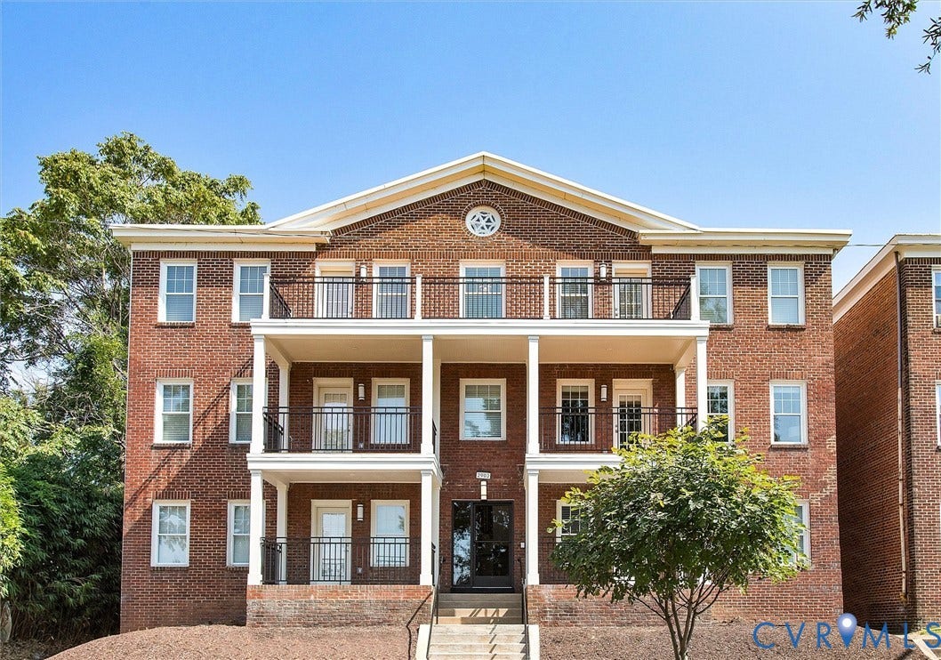 2902 Idlewood, #5, Richmond, VA 23221 Brick exterior featuring white double-hung windows, two levels of balconies with black metal railings, and a central entryway