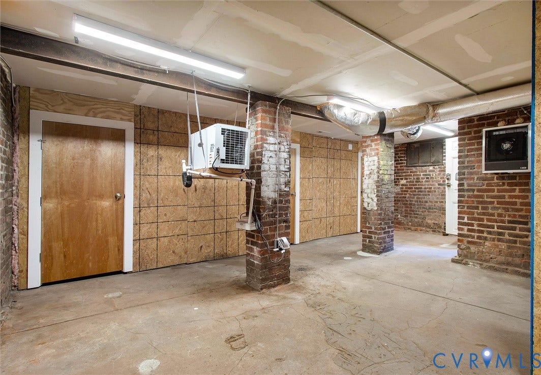 2902 Idlewood, #5, Richmond, VA 23221 Concrete flooring, exposed brick structural columns, unfinished wood paneling, and overhead fluorescent lighting