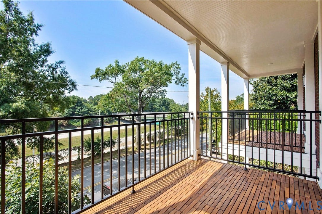 2902 Idlewood, #5, Richmond, VA 23221 Covered balcony featuring wood-finish flooring, white columns, a white beadboard ceiling, and black metal railings