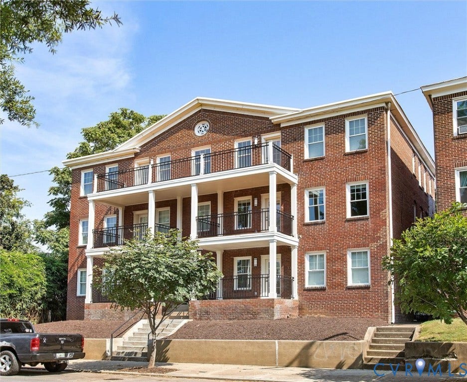 2902 Idlewood, #5, Richmond, VA 23221 Brick facade building featuring multiple balconies with black wrought iron railings, white columns, and a prominent portico