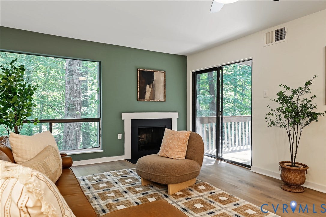 10272 Iron Mill Road, North Chesterfield, VA 23235 Fireplace with white mantel, wide window, wood-finish flooring, sliding glass door, and a ceiling fan