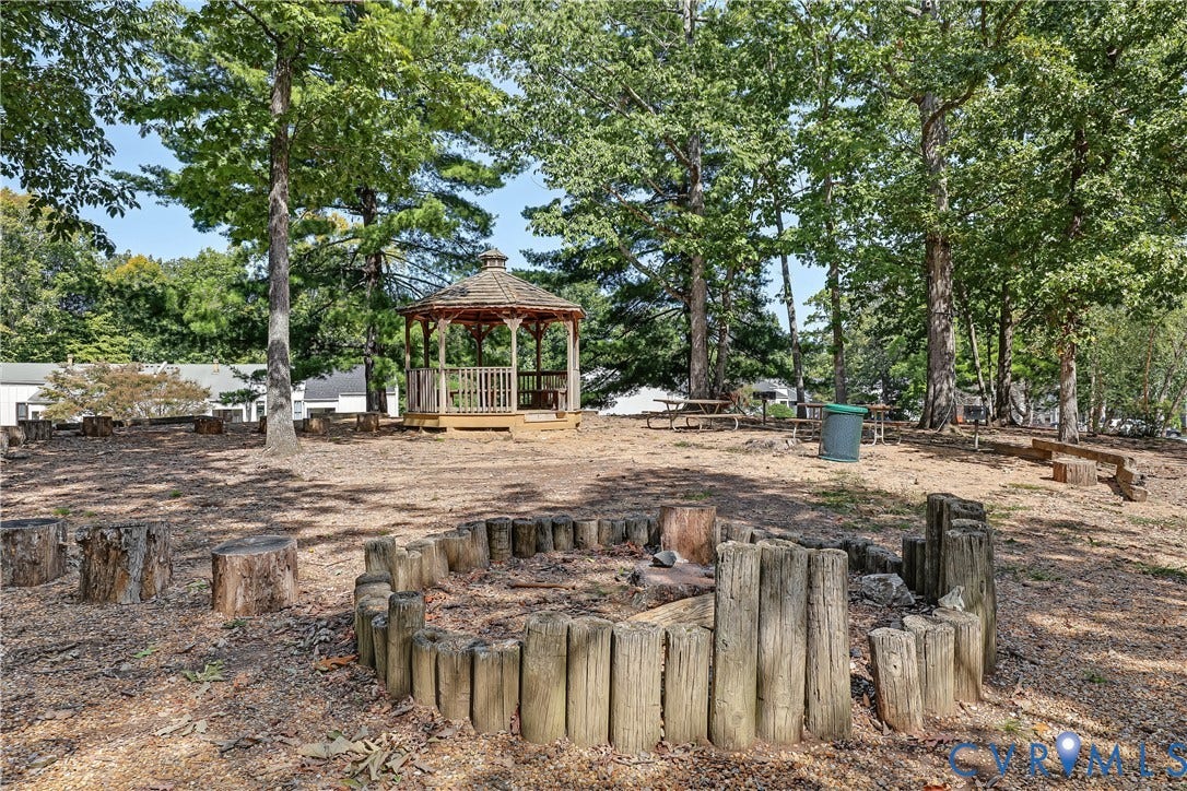 10272 Iron Mill Road, North Chesterfield, VA 23235 Expansive outdoor space featuring a wood gazebo, multiple mature trees, and a built-in fire pit constructed with wood posts