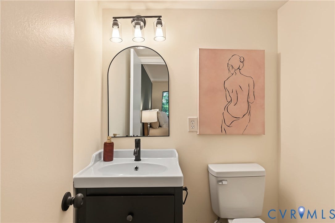 10272 Iron Mill Road, North Chesterfield, VA 23235 Modern vanity with a white basin and matte black faucet, illuminated by a three-light fixture