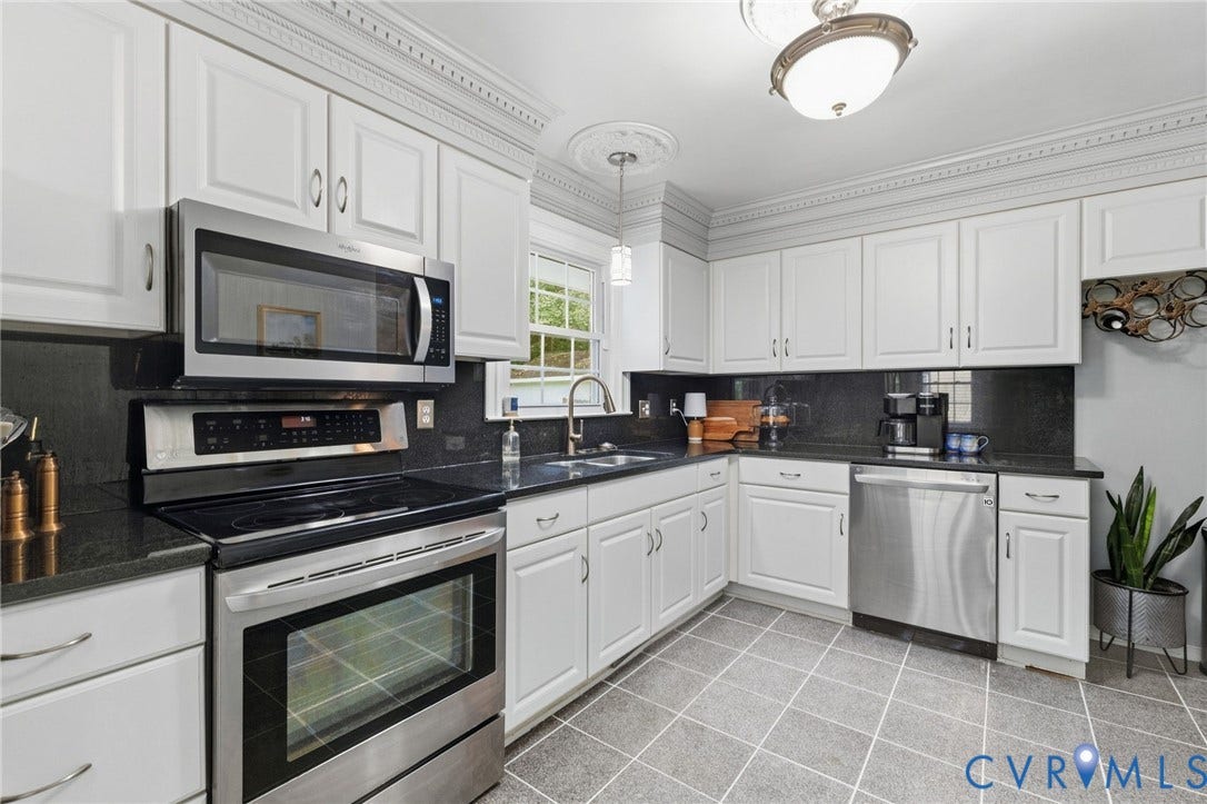 6723 Cherry Road, Woodhaven Shores, Quinton, VA 23141 White cabinetry with crown molding, stainless steel appliances, dark countertops, tiled flooring, and a stainless steel sink with a gooseneck faucet