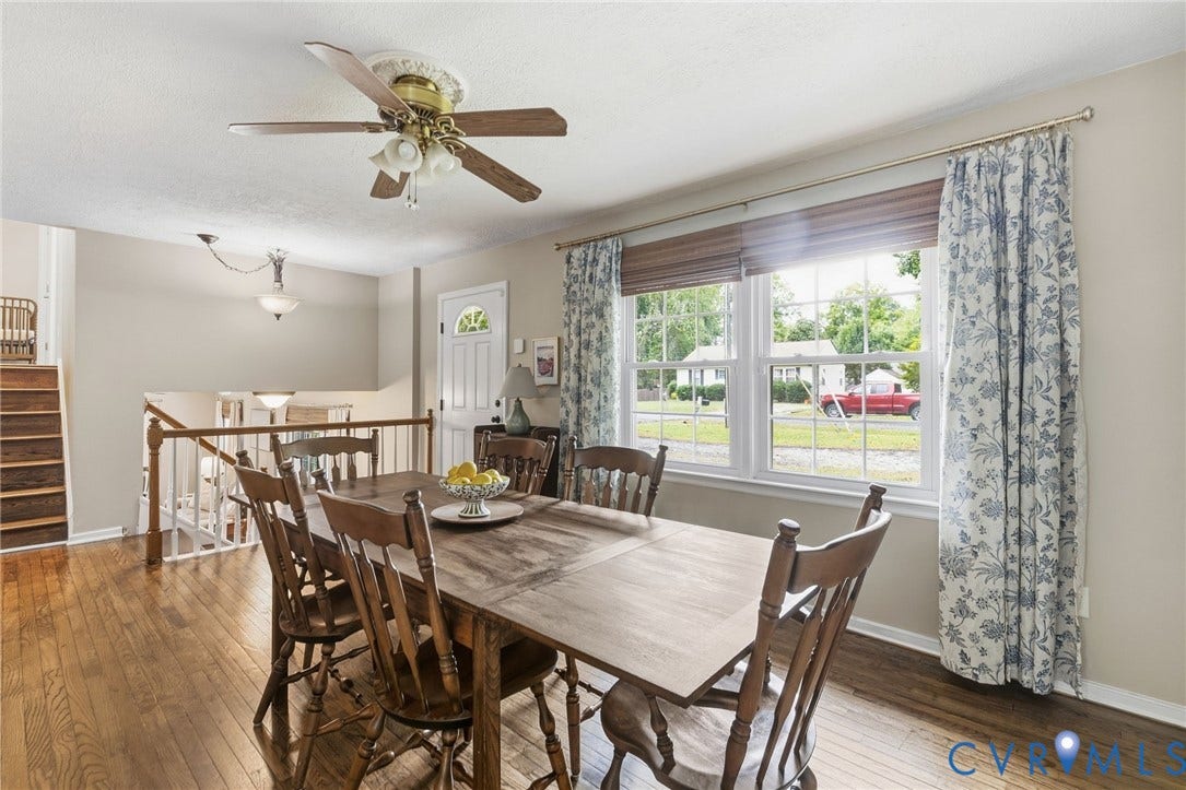 6723 Cherry Road, Woodhaven Shores, Quinton, VA 23141 Hardwood flooring throughout, large window with natural light, ceiling fan with integrated lighting, white paneled door with arched glass insert, and open railing overlooking lower level
