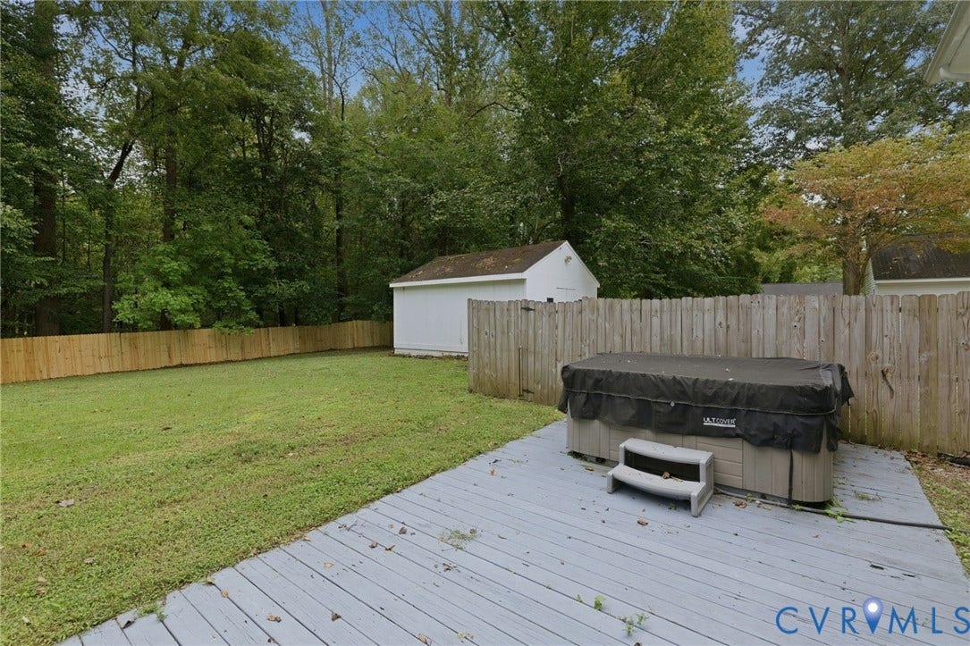 6723 Cherry Road, Woodhaven Shores, Quinton, VA 23141 Expansive backyard featuring a wood privacy fence, a wooden deck, a hot tub, a storage shed, and mature trees